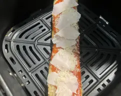 Step <p>Sitúalo en tu freidora de aire y pon programa pizza en la mía son 170° ocho minutos</p> illustration